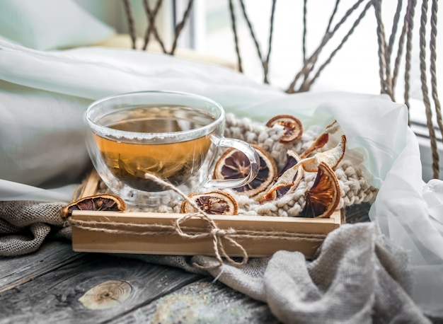 木製の背景上のお茶の透明なカップのある静物