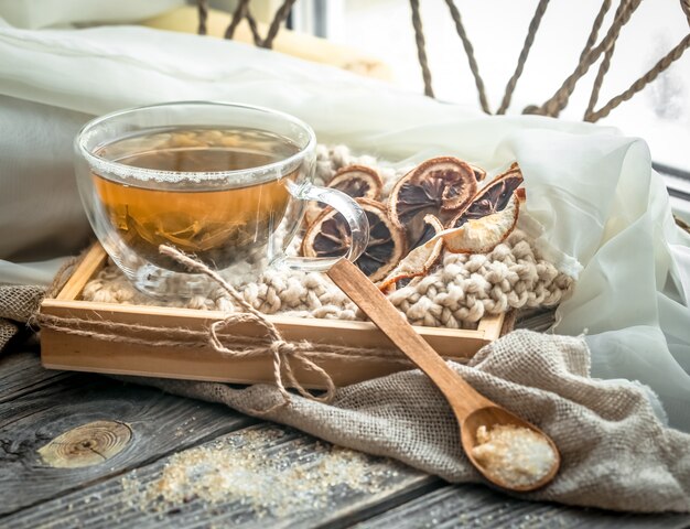 木製の背景上のお茶の透明なカップのある静物