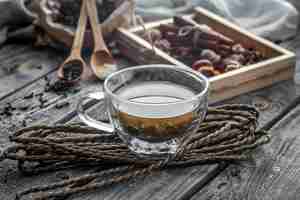 Free photo still life with transparent and fragrant cup of tea with ginger on wooden background