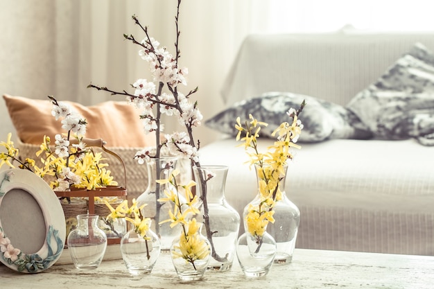 Free photo still life with vases with spring flowers in the living room