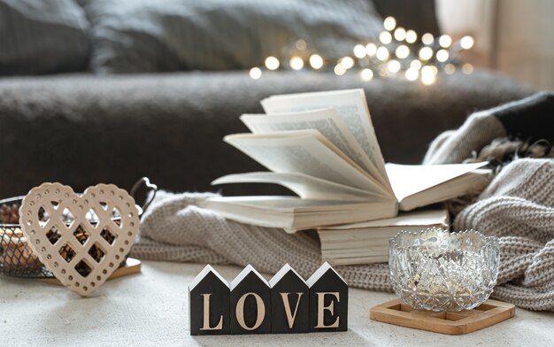 Still life with wooden word love, books and cozy items on a blurred background with boke.