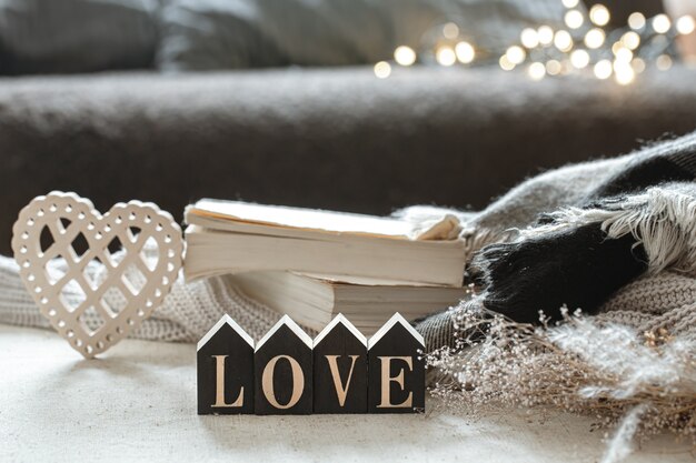 Still life with wooden word love, books and cozy items on a blurred background with boke.