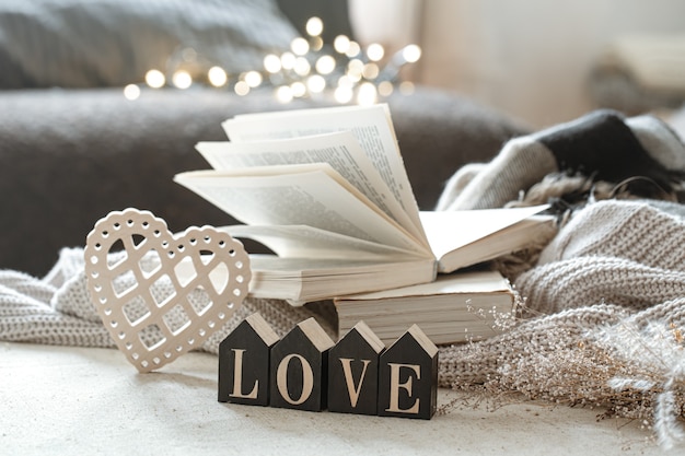 木製の言葉の愛、本、そしてボケのある居心地の良いアイテムのある静物。
