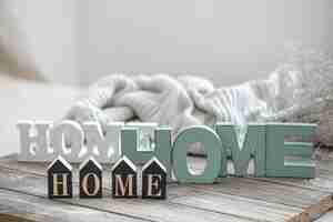 Free photo still life with the words home for home decor on blurred background. the concept of home coziness and comfort.
