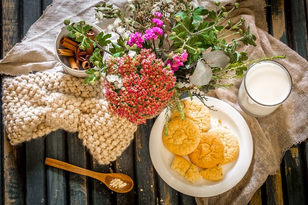 Still life on a wooden table with  plate of cookies and glass  milk