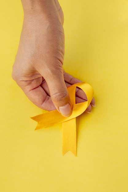 Free photo still life of yellow ribbon in hand