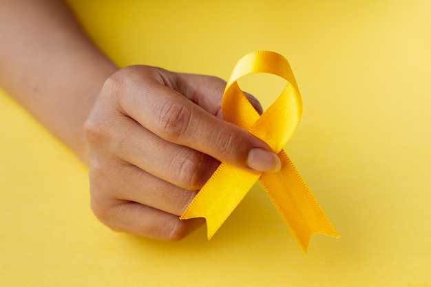 Free photo still life of yellow ribbon in hand