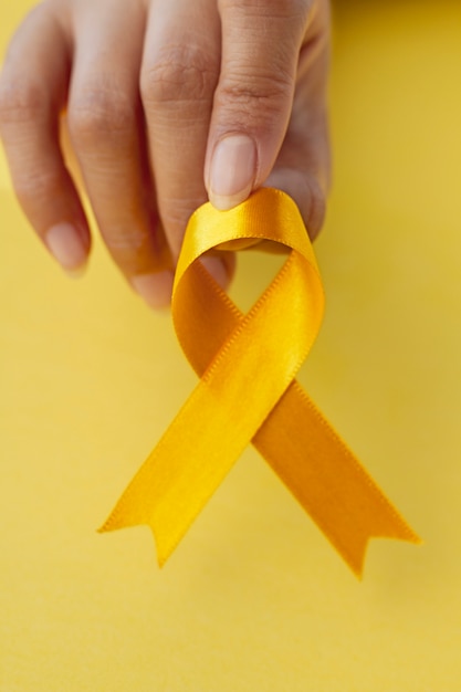 Free photo still life of yellow ribbon in hand