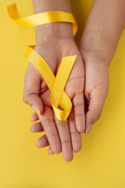 Free photo still life of yellow ribbon in hand