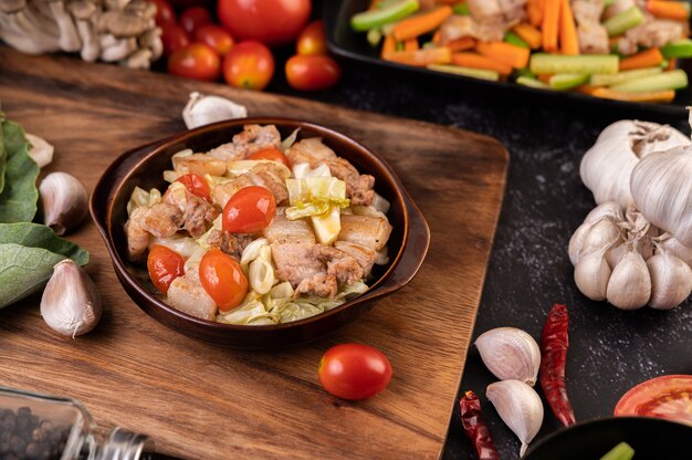 Stir cabbage with pork belly in a plate on a wooden plate.