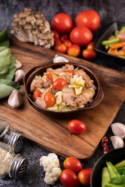 Stir cabbage with pork belly in a plate on a wooden plate.