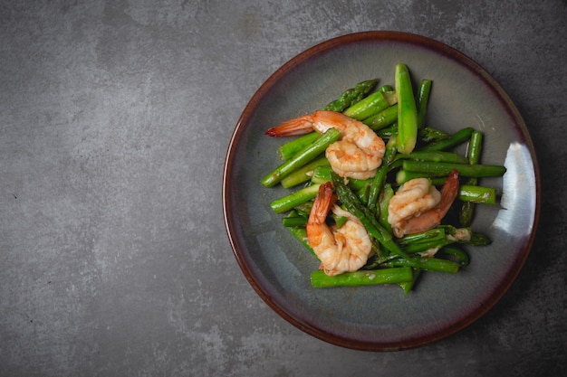 Foto gratuita mescolare gli asparagi fritti e i gamberi sul tavolo.