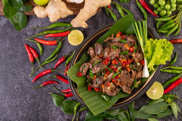 Stir-fried chicken liver basil on banana leaves in a black dish