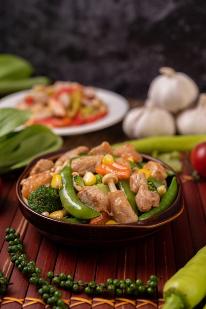Free photo stir-fried mixed vegetables containing green peas, carrots, mushrooms, corn, broccoli, and pork