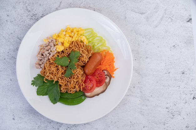 Stir-fried noodles with minced pork, edamame, tomatoes and mushrooms in a white plate.