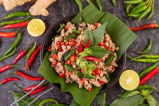 Free photo stir-fried pork basil on banana leaves in a frying pan.