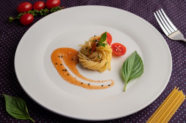 Foto gratuita spaghetti in padella splendidamente disposti in un piatto bianco.