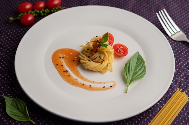 Обжаренные спагетти красиво оформлены в белой тарелке.