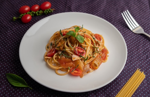 Обжаренные спагетти красиво оформлены в белой тарелке.