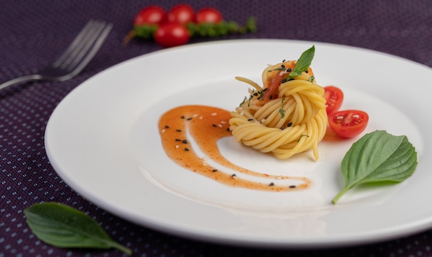 Foto gratuita spaghetti in padella splendidamente disposti in un piatto bianco.