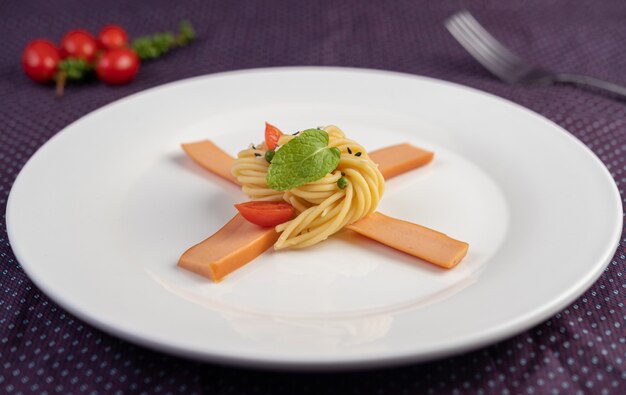 하얀 접시에 아름답게 배열 된 볶은 스파게티.
