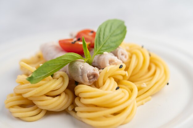 Stir-fried spaghetti and pork, beautifully arranged in a white plate.