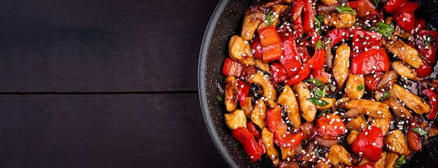 Stir fry chicken, sweet peppers and green onion. Top view. Asian cuisine