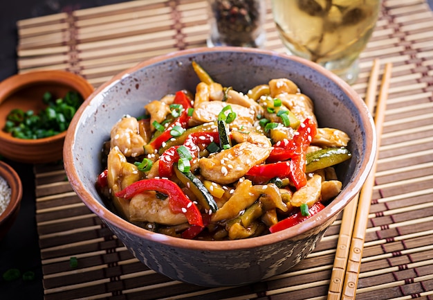 Free photo stir fry chicken, zucchini, sweet peppers and green onion