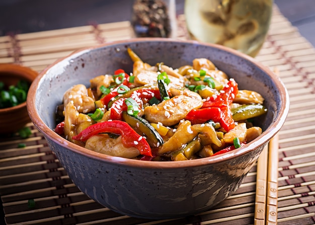 Free photo stir fry chicken, zucchini, sweet peppers and green onion