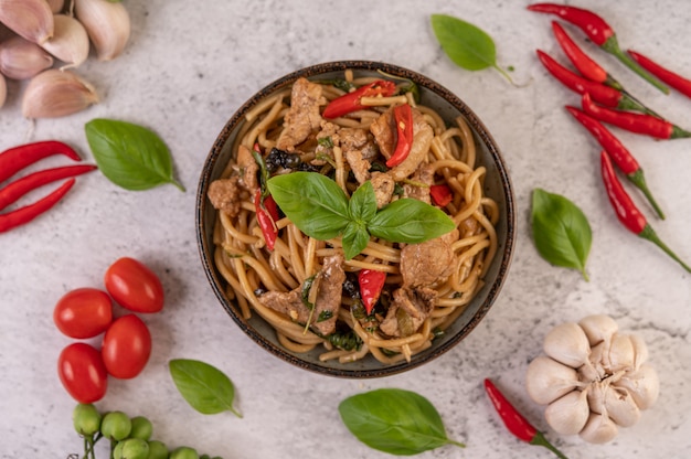 Foto gratuita soffriggere gli spaghetti e mettere il maiale in una ciotola.