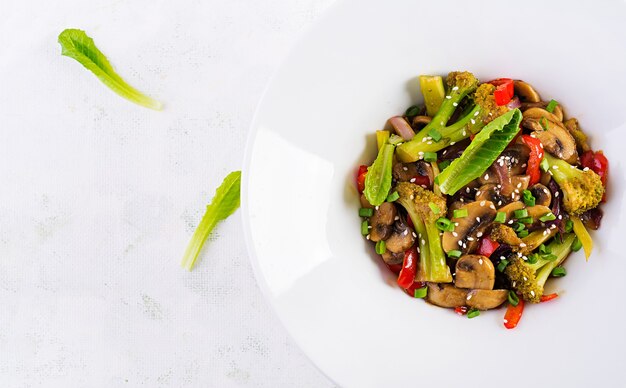 Stir fry vegetables with mushrooms, paprika, red onions and broccoli. Healthy food. Asian cuisine. Top view, overhead