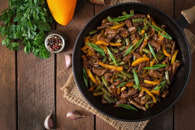 Stir frying beef with sweet peppers and green beans