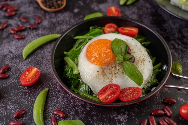 Stir kale and fried egg in a pan.