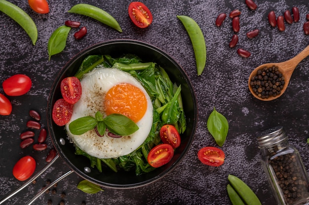 Stir kale and fried egg in a pan.