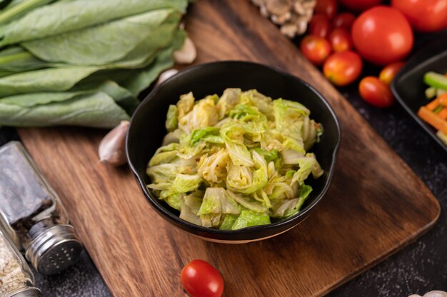 Stir the white cabbage with oyster sauce on a black plate.