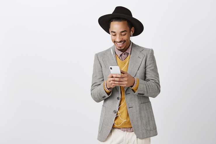 Free Photo stlylish african-american man in suit using smartphone and listening music in earphones