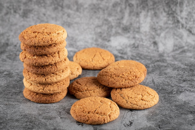 A stock of oatmeal cookies on grey concrete.