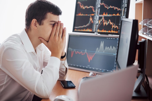 Stockbroker in shirt is working in a monitoring room with display screens. stock exchange trading forex finance graphic concept. businessmen trading stocks online