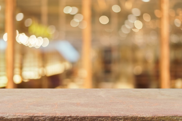 Stone board empty table in front of blurred background. Perspective brown stone over blur in coffee shop - can be used for display or montage mock up your products. vintage filtered image.