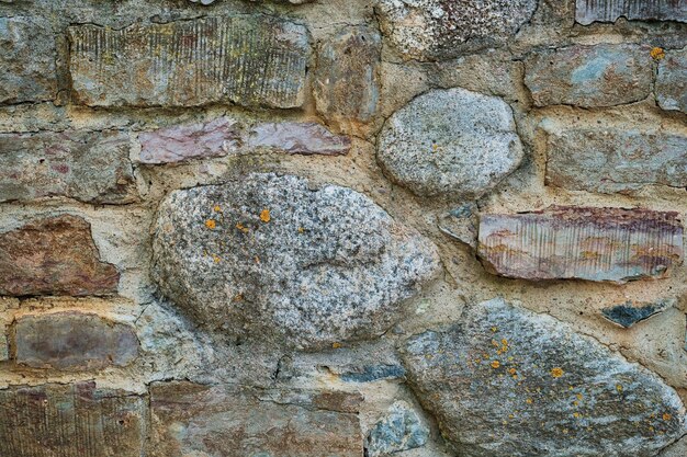 Stone gray wall made of raw rough stone background texture stones of different sizes Idea for house or building facade design and public space