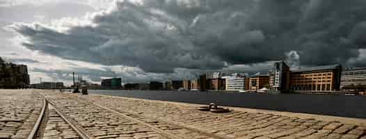 Бесплатное фото Каменная дорога в окружении зданий под темным облачным небом