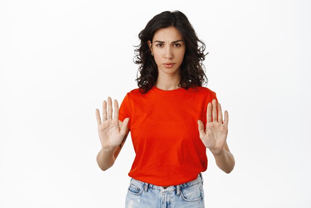 Stop keep distance Serious frowning girl shows block telling no refuse and decline something bad unappropriate standing against white background