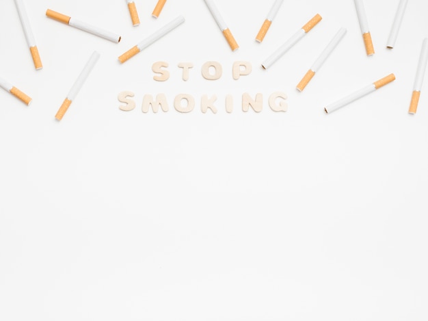 無料写真 白い背景の上のタバコとメッセージを停止します。