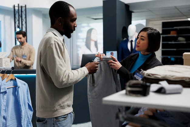 Store assistant helping choosing pants