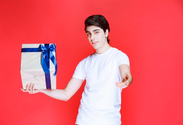 Storeman holding a white gift box and asking for payment