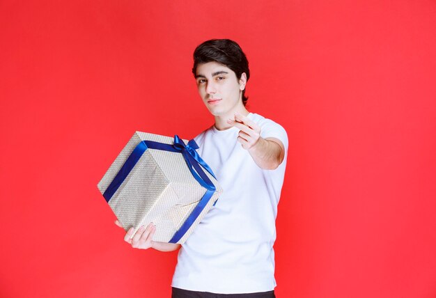 Storeman holding a white gift box and asking for payment