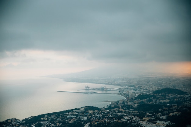 Free photo stormy clouds over the mountain cityscape