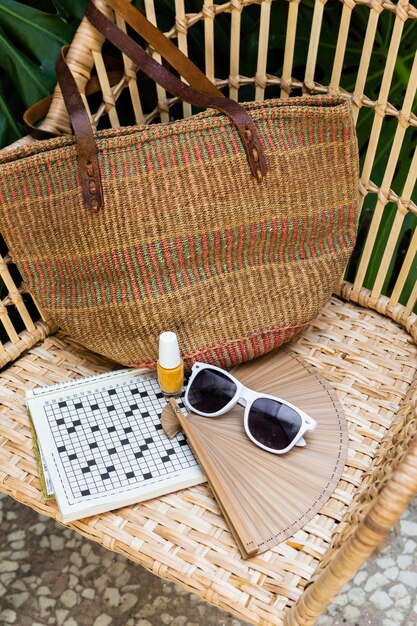 Straw chair and travel items arrangement high angle