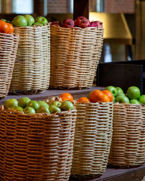 Straw fruit baskets filled with apples, pomegranates and oranges