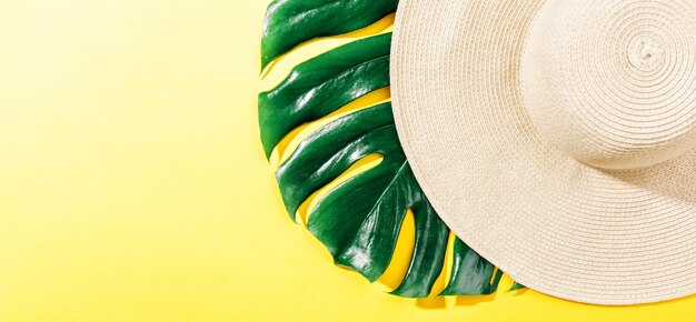 Straw hat on bright yellow sunny background